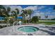 Community hot tub and surrounding landscaping featuring palm trees and an outdoor seating area at 2469 Paradise Plum Dr, Sarasota, FL 34240
