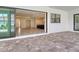 A covered patio with brick pavers and a view through sliding doors of the living spaces at 2469 Paradise Plum Dr, Sarasota, FL 34240