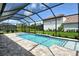 Outdoor pool with a screened-in enclosure surrounded by brick pavers and green yard at 2469 Paradise Plum Dr, Sarasota, FL 34240