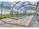 Backyard pool and spa with screen enclosure and manicured landscaping in residential neighborhood at 2469 Paradise Plum Dr, Sarasota, FL 34240