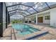 Screened-in pool and hot tub are surrounded by brick pavers, offering a backyard retreat at 2469 Paradise Plum Dr, Sarasota, FL 34240