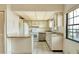 A bright kitchen featuring white appliances, a tiled backsplash, and an open layout at 2727 75Th W St # 1Af, Bradenton, FL 34209