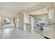 Bright kitchen with white appliances, light tile floors, and an open layout looking into the living room at 2727 75Th W St # 1Af, Bradenton, FL 34209