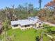 Aerial view of charming home with lush yard and new metal roof, surrounded by mature trees at 3001 Bay Shore Cir, Sarasota, FL 34234