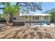 Backyard features a hot tub, outdoor seating, mature trees, and green space at 3001 Bay Shore Cir, Sarasota, FL 34234