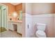 Vintage bathroom with pink tile, vanity, toilet, and updated fixtures at 3001 Bay Shore Cir, Sarasota, FL 34234