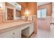 Vintage bathroom with pink tile, classic vanity, and built in shower at 3001 Bay Shore Cir, Sarasota, FL 34234