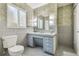 Bathroom boasts unique wallpaper, vintage vanity, and a window for natural light at 3001 Bay Shore Cir, Sarasota, FL 34234