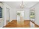 Bright dining room shows hardwood floors, chandelier, and access to other rooms and outdoor patio at 3001 Bay Shore Cir, Sarasota, FL 34234