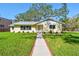Charming yellow single-story home with a well-manicured lawn and inviting walkway at 3001 Bay Shore Cir, Sarasota, FL 34234