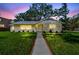 Inviting home with a well-manicured lawn, enhancing its curb appeal at twilight at 3001 Bay Shore Cir, Sarasota, FL 34234
