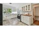 Well-lit kitchen featuring white cabinetry, stainless steel oven, tile flooring, and natural light at 3001 Bay Shore Cir, Sarasota, FL 34234