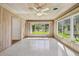 Bright living room with wood paneling, ceiling fan, and large windows offering outdoor views at 3001 Bay Shore Cir, Sarasota, FL 34234