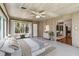 Bright main bedroom has a wood paneled ceiling and walls, large windows and an adjacent dining room at 3001 Bay Shore Cir, Sarasota, FL 34234