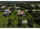 Aerial perspective of a home featuring a pool, basketball court, and landscaped surroundings, creating a private oasis at 306 Country Meadows Way, Bradenton, FL 34212