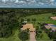 Aerial view of home and expansive lawn surrounded by mature trees at 306 Country Meadows Way, Bradenton, FL 34212