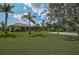 Spacious backyard with a basketball court, screened-in pool, and lush green lawn, ideal for outdoor enjoyment at 306 Country Meadows Way, Bradenton, FL 34212