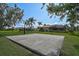 Basketball court in the backyard near well-maintained homes and green lawns, perfect for recreational activities at 306 Country Meadows Way, Bradenton, FL 34212