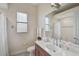Bright bathroom with a large mirror, vanity with sink, and tiled shower at 306 Country Meadows Way, Bradenton, FL 34212