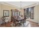 Formal dining room with a wood table, china cabinet, chandelier and sunlit window at 306 Country Meadows Way, Bradenton, FL 34212