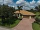 Home with brick driveway, mature trees, and well-manicured lawn at 306 Country Meadows Way, Bradenton, FL 34212