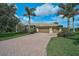Exterior elevation features a well-manicured lawn and a brick paver driveway at 306 Country Meadows Way, Bradenton, FL 34212