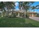 Beautiful single-story home with a well-manicured lawn, mature trees, and a charming red brick driveway at 306 Country Meadows Way, Bradenton, FL 34212