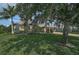 Charming single-story home with a tile roof, mature trees, lush landscaping, and a well-manicured lawn at 306 Country Meadows Way, Bradenton, FL 34212