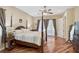 Large main bedroom with hardwood floors, four poster bed, and ample natural light through large windows at 306 Country Meadows Way, Bradenton, FL 34212