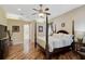 Spacious main bedroom with hardwood floors, a four-poster bed, and ensuite bathroom access at 306 Country Meadows Way, Bradenton, FL 34212