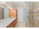 Well-lit bathroom features double sinks, a linen closet, and a glass enclosed shower with tiled walls at 315 Sapphire Lake Dr # 101, Bradenton, FL 34209