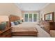 Bright bedroom with shutters offers a wicker bed frame, neutral colors, and abundant natural light at 315 Sapphire Lake Dr # 101, Bradenton, FL 34209