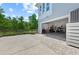 Two-car garage accessible from a paved driveway, with a well-kept lawn and a view of natural landscape at 315 Sapphire Lake Dr # 101, Bradenton, FL 34209