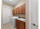 Laundry room with cabinets, sink, washer, dryer, and a door to the exterior at 315 Sapphire Lake Dr # 101, Bradenton, FL 34209