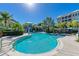 Bright turquoise community pool with steps for easy entry, palm trees, and lush landscaping all around at 315 Sapphire Lake Dr # 101, Bradenton, FL 34209