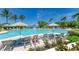 Large swimming pool with lounge chairs and umbrellas surrounded by trees and manicured landscaping at 315 Sapphire Lake Dr # 101, Bradenton, FL 34209