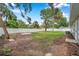 Spacious backyard featuring a white vinyl fence and mature trees, ideal for outdoor activities and privacy at 3153 Irving St, Sarasota, FL 34237