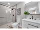Modern bathroom with glass shower, white vanity with dark pulls, black hardware, and a decorative mirror at 3153 Irving St, Sarasota, FL 34237