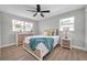 Spacious bedroom with wood floors, two windows, ceiling fan, and light gray walls at 3153 Irving St, Sarasota, FL 34237