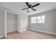A simple bedroom with wood-look floors, light grey walls, bi-fold closet doors, and plenty of light at 3153 Irving St, Sarasota, FL 34237