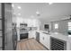 Open kitchen with stainless appliances, white cabinets, marble countertop and a view into the living room at 3153 Irving St, Sarasota, FL 34237