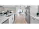 Open concept kitchen with stainless-steel refrigerator and dishwasher with view to dining and living rooms at 3153 Irving St, Sarasota, FL 34237