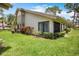 A clean single-story home exterior with a well-manicured lawn and bushes at 3362 Sandleheath # 12, Sarasota, FL 34235