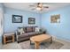 Living room with blue walls, tile floors, and a gray sofa at 3362 Sandleheath # 12, Sarasota, FL 34235