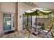 Inviting outdoor patio space with a table, chairs, and a green umbrella at 3362 Sandleheath # 12, Sarasota, FL 34235