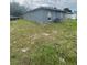 The backyard is grassy, extending from the house's gray exterior at 3622 N 51St St, Tampa, FL 33619