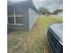 Side view of the house with a car in the driveway showing the exterior and yard at 3622 N 51St St, Tampa, FL 33619