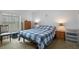 Bedroom with blue and white quilt, window, lamps, and neutral carpet at 3818 Chris Dr, Wesley Chapel, FL 33543