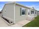 Angle view of the exterior with green siding and decorative brick planter at 3818 Chris Dr, Wesley Chapel, FL 33543