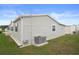 View of the home's exterior showing the vinyl siding, lawn, and AC unit at 3818 Chris Dr, Wesley Chapel, FL 33543